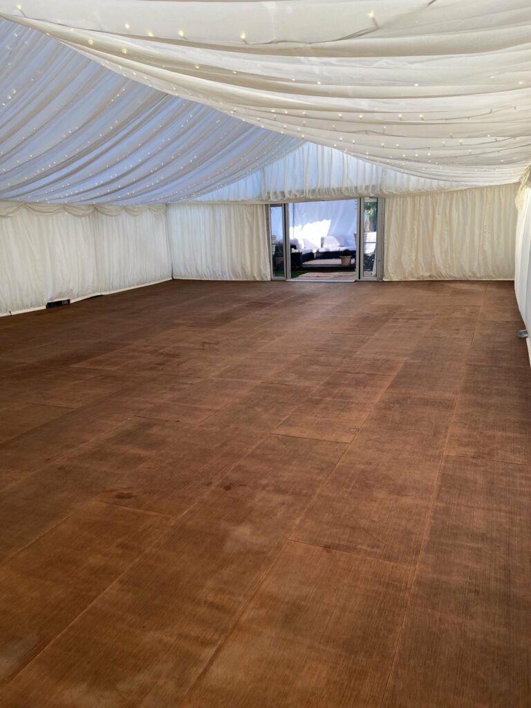 Rustic Christmas marquee setup with barrel tables and festive lighting – furniture to hire from Red Woodpecker Event Hire.