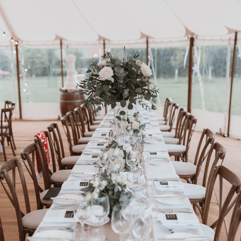 Rustic wedding chair to hire setup with Crossback chairs in marquee.