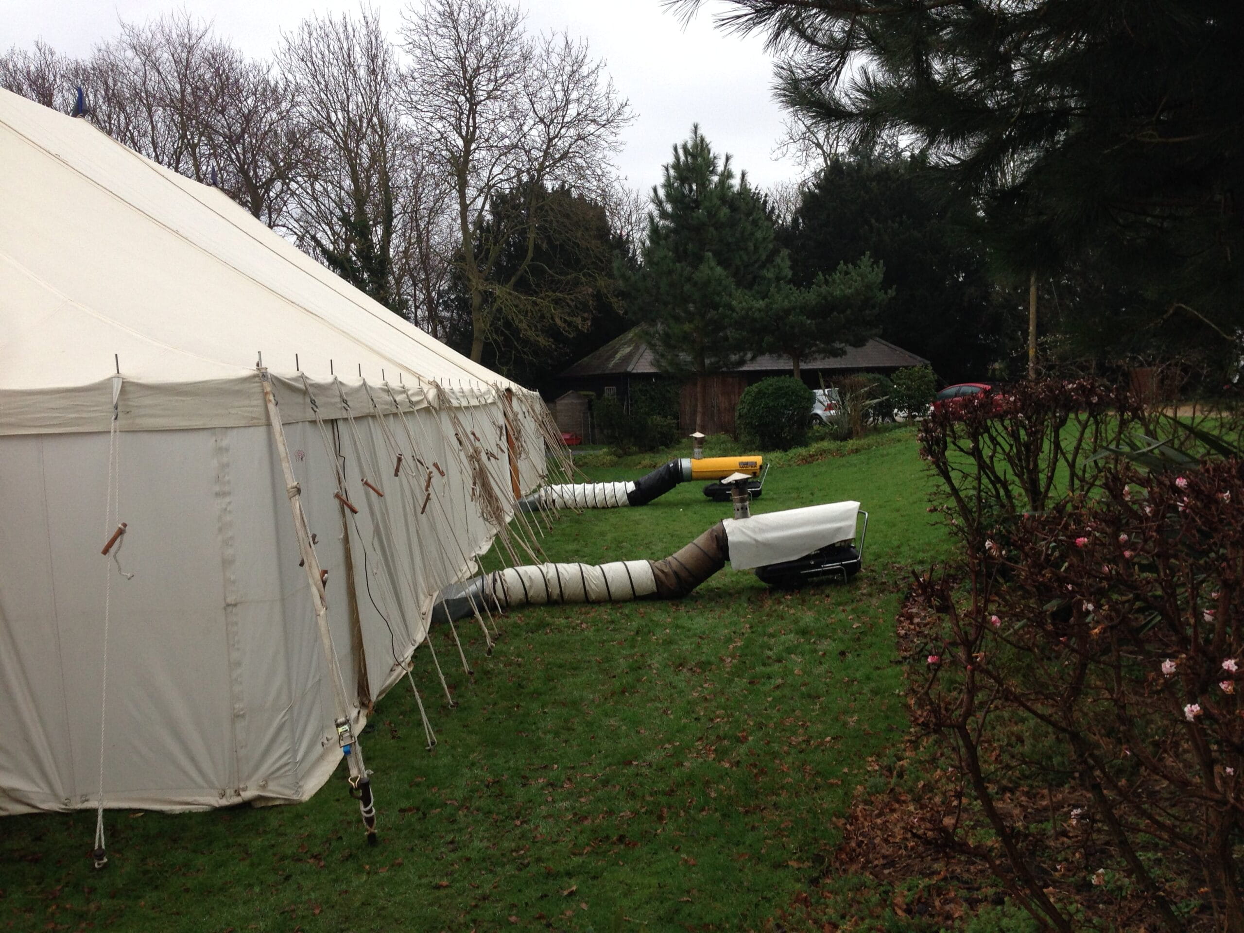 Two marquee heaters on grass outside a white marquee